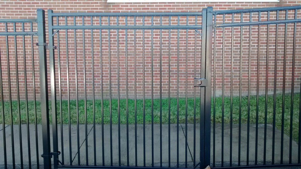 Powder-coated steel ornamental fence with decorative pickets installed around a residential property