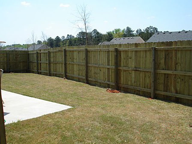 Wooden privacy fence with vertical cedar boards installed by McIntyre Fencing